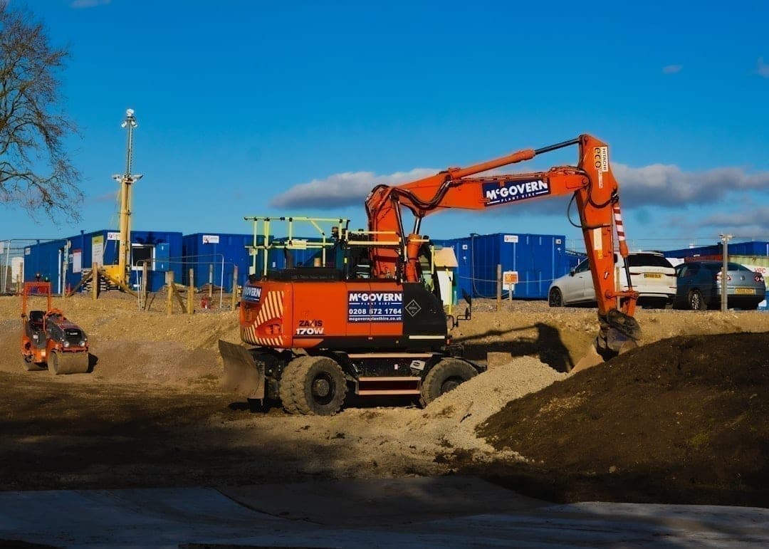 Heavy excavation equipment operating on a construction site where ground vibration from machinery can affect nearby structures