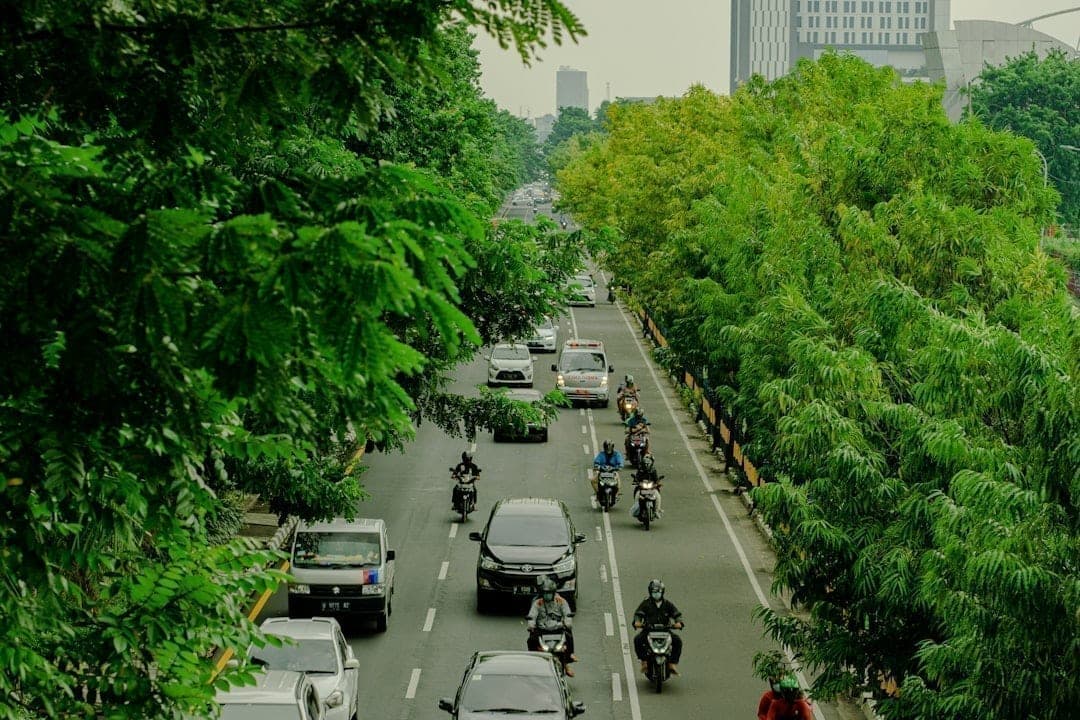 Rue urbaine animée avec trafic dense et grands immeubles, illustrant l'exposition à la pollution dans les communautés urbaines