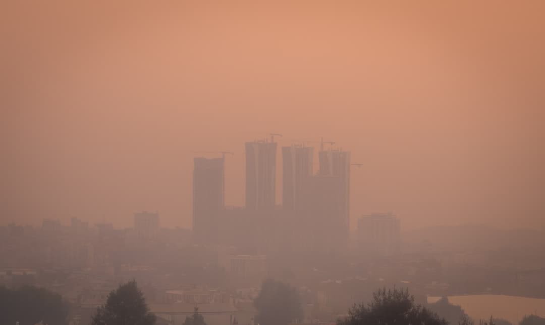Horizonte de ciudad europea oscurecido por una neblina de smog, ilustrando la crisis de contaminación del aire del continente