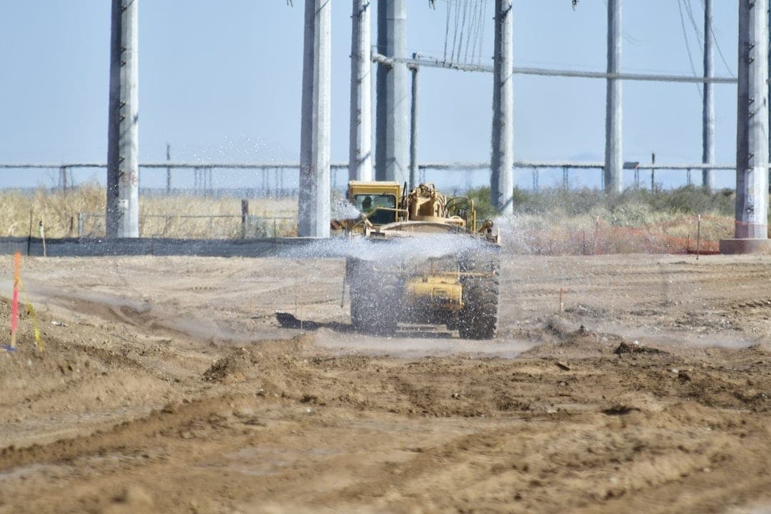 Maquinaria pesada operando en una obra de construcción, el tipo de entorno donde los sensores de monitorización solar eliminan la dependencia energética