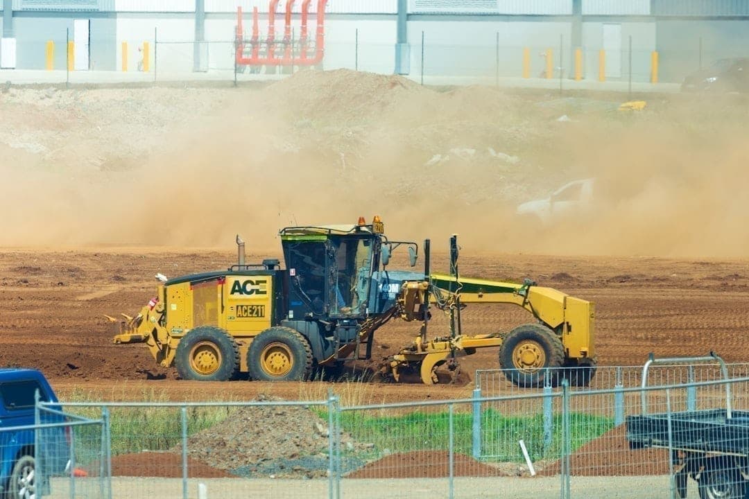 Engins lourds sur un chantier, générant poussière et vibration nécessitant une surveillance intégrée