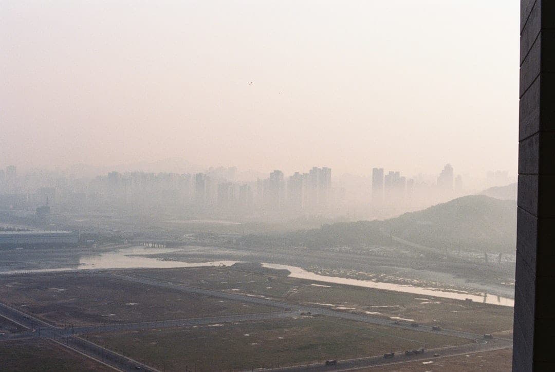 Horizon urbain obscurci par le smog, illustrant le défi mondial de la pollution atmosphérique visé par la feuille de route de l'OMS