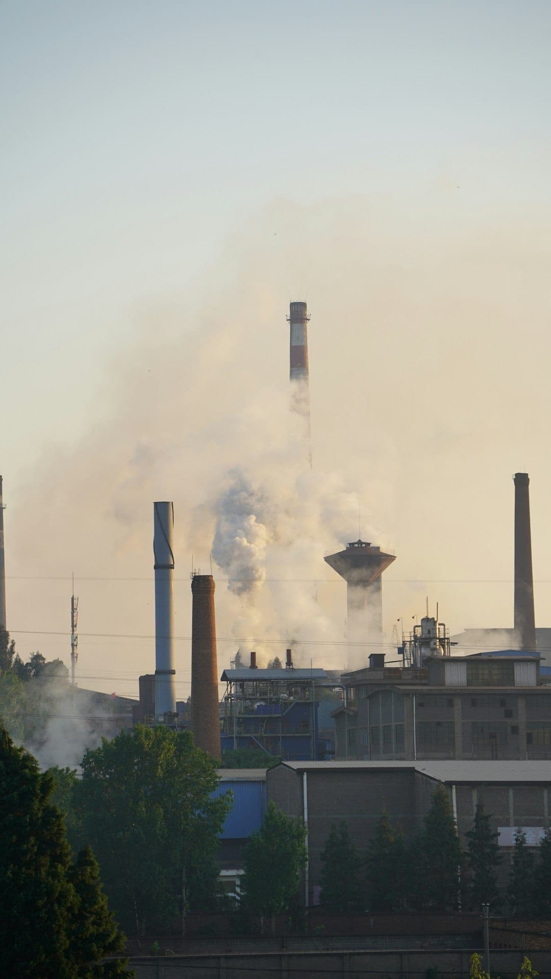 Industrial factory with smoke billowing from chimneys during steel production